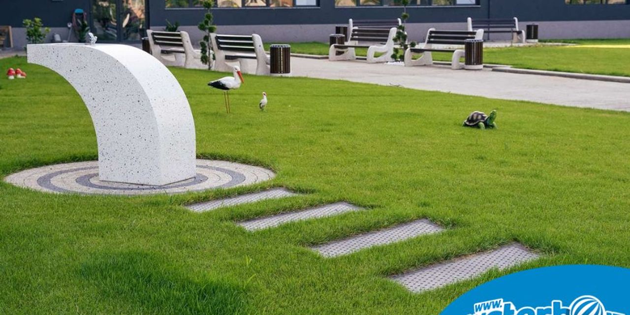 Cișmea urbană amplasată într-un parc rezidențial modern, cu spații verzi, alei pietonale și mobilier urban. Cișmea urbană amplasată într-un parc rezidențial modern, cu spații verzi, alei pietonale și mobilier urban.