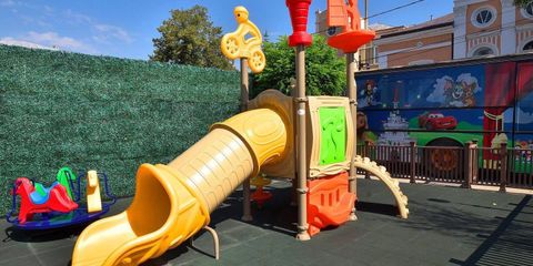 Complex de joacă pentru exterior amplasat pe terasa unui restaurant family-friendly, cu tobogan, elemente de cățărare și suprafață de siguranță pentru copii. Complex de joacă pentru exterior amplasat pe terasa unui restaurant family-friendly, cu tobogan, elemente de cățărare și suprafață de siguranță pentru copii.