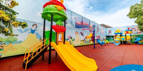 Tobogan și echipamente de joacă pentru copii într-un loc de joacă școlar cu suprafață de impact din cauciuc Tobogan și echipamente de joacă pentru copii într-un loc de joacă școlar cu suprafață de impact din cauciuc